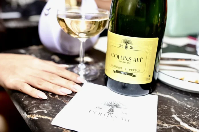 A hand near a bottle of champagne.
